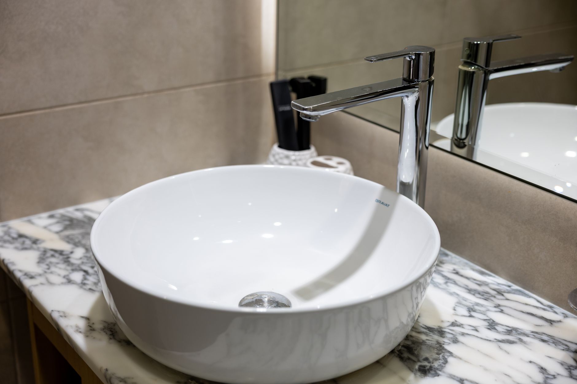 Stylish bathroom sink with a chrome faucet and marble countertop, ideal for contemporary interior design in Round Rock, TX